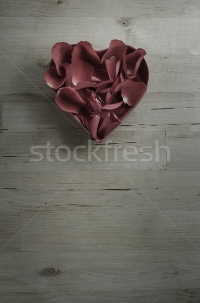 Plum Toned Rose Petals in Heart Shaped Bowl on Wood Stock photo © frannyanne