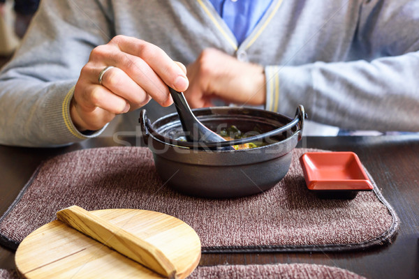 A man eating miso soup in a traditional japanese restaurant Stock photo © frimufilms