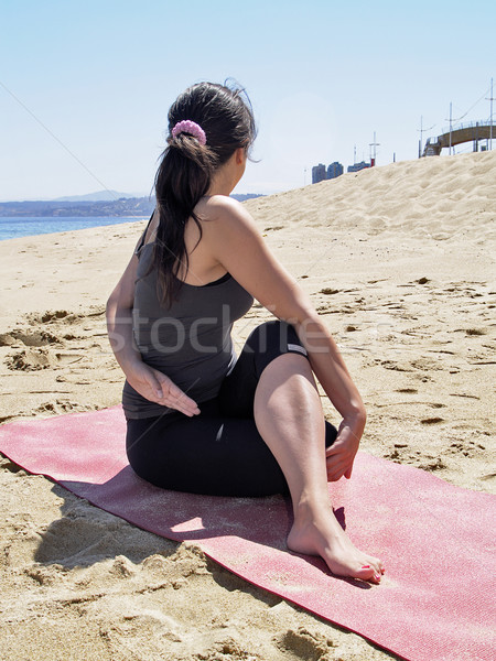 Bikram yoga arda matsyendrasana pose at beach Stock photo © fxegs