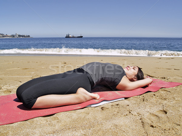 Bikram yoga supta bajrasana pose at beach Stock photo © fxegs