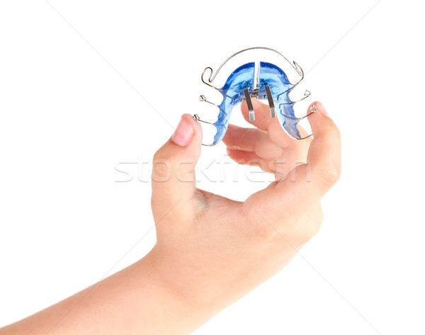 Orthodontic treatment in a child's hand, isolated on a white background Stock photo © g215