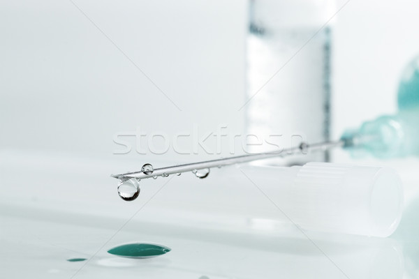 Stock photo: Medical syringe with injection solution drop. Shallow depth of f