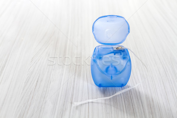 Dental floss on a wooden background. Stock photo © g215