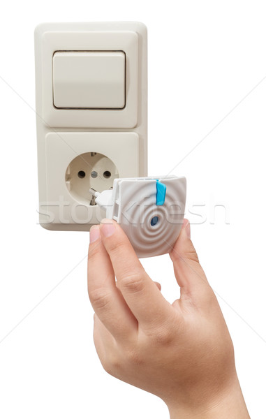 Stock photo: Woman's hand includes Anti-mosquito fumigator in the socket