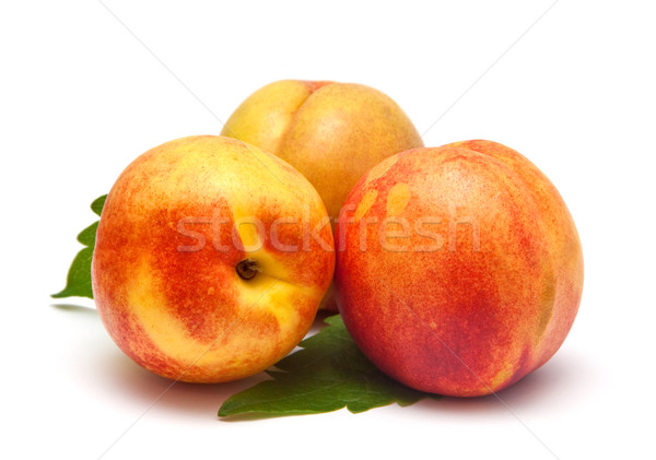 Ripe nectarines on the green leaves isolated on white background. Stock photo © g215