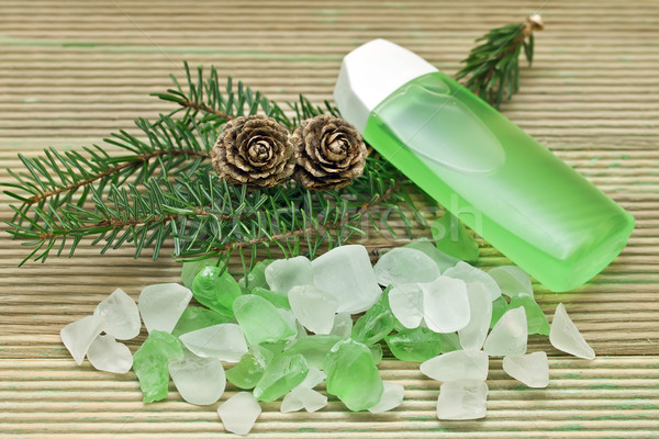 Stock photo: Coniferous extract bath with a sprig of pine needles, pine cones and bath salts.