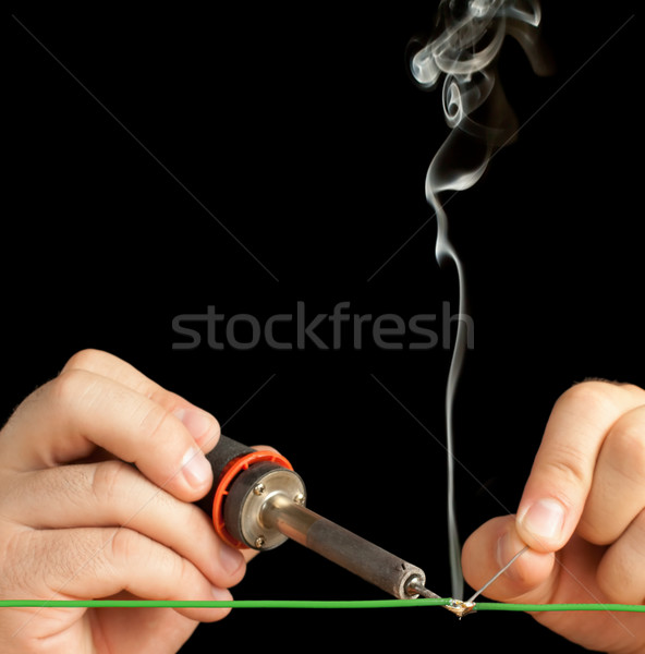 [[stock_photo]]: Technicien · à · souder · deux · fils · ensemble · noir