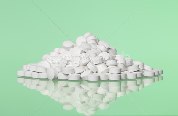 Stack of pills towards green background Stock photo © gemenacom