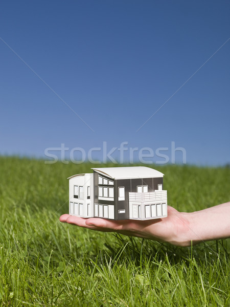 Man holding a miniature house outside in the sun. Stock photo © gemenacom