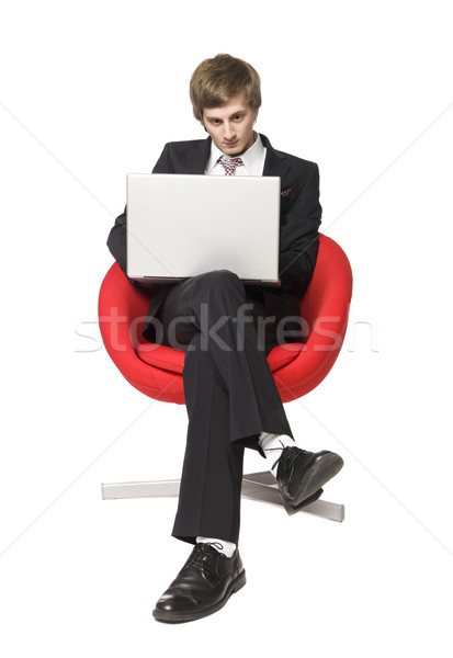 A boy in a red armchair with a laptop Stock photo © gemenacom