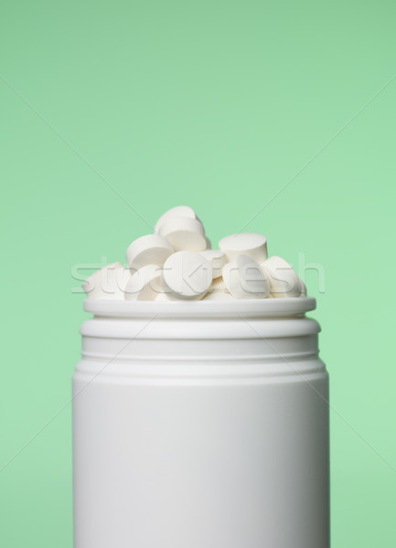 Stock photo: Can of pills toward green background