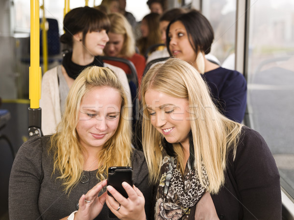 Nők mobiltelefon fiatal nő néz lányok idő Stock fotó © gemenacom