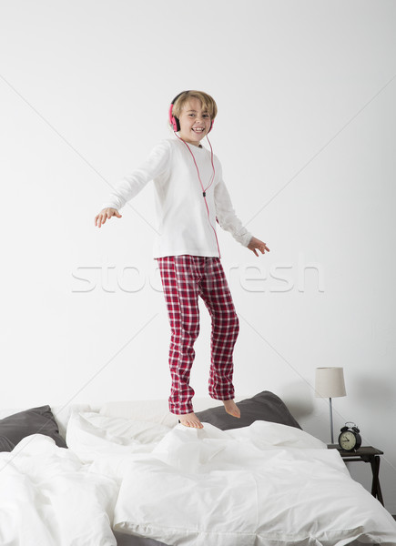 Kleines Mädchen Kopfhörer springen Bett lächelnd Musik Stock foto © gemenacom