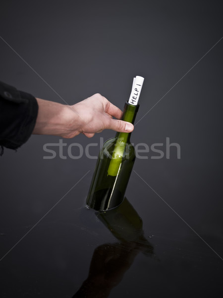 Hand picking up a bottle with a message in it. Stock photo © gemenacom