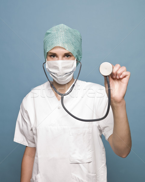 Stock photo: Female nurse with surgical mask and a stethoscope