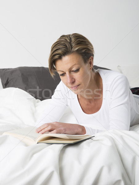 женщину чтение книга кровать взрослый короткие волосы Сток-фото © gemenacom