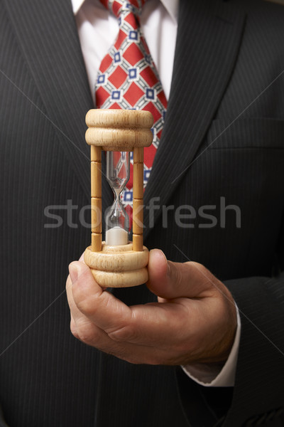 Businessman holding hourglass Stock photo © gemphoto