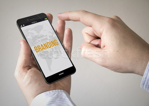 Stock photo:  touchscreen smartphone with branding on the screen
