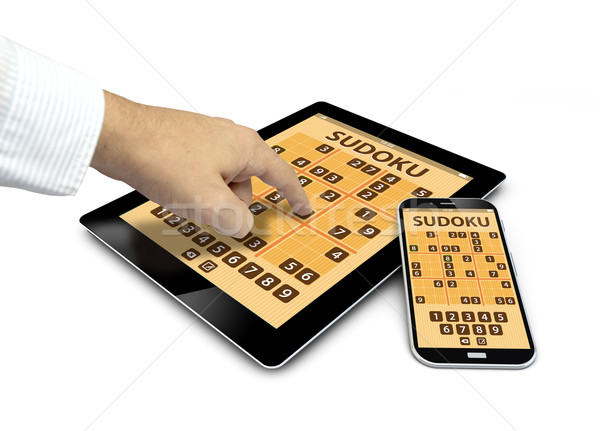 group of touchscreen devices with sudoku game and a finger touch Stock photo © georgejmclittle