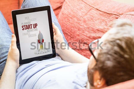 hipster on the sofa with virus alert on a tablet Stock photo © georgejmclittle