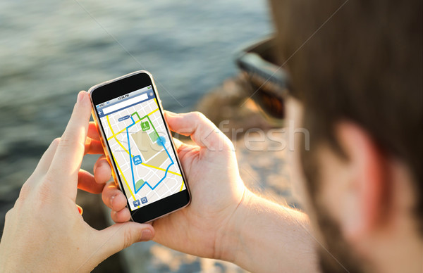 Man using his GPS of mobile phone on the coast  Stock photo © georgejmclittle