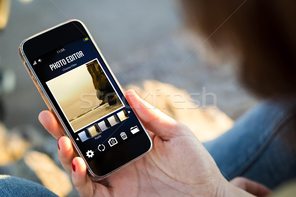 woman sitting in the street holding her smartphone with photo ed Stock photo © georgejmclittle