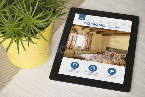 Tablet booking over a table with plant Stock photo © georgejmclittle