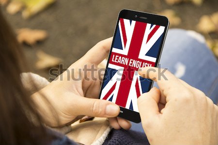 woman sitting in the street holding her smartphone and learning  Stock photo © georgejmclittle