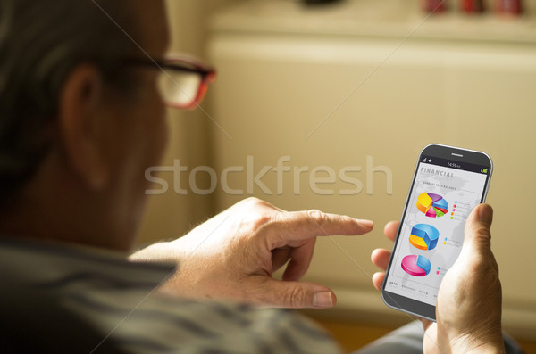 Portrait of a mature man with finances app in a mobile phone Stock photo © georgejmclittle