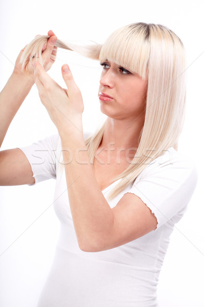 Portrait of beautiful girl touching her weak hair and looking sad Stock photo © georgemuresan