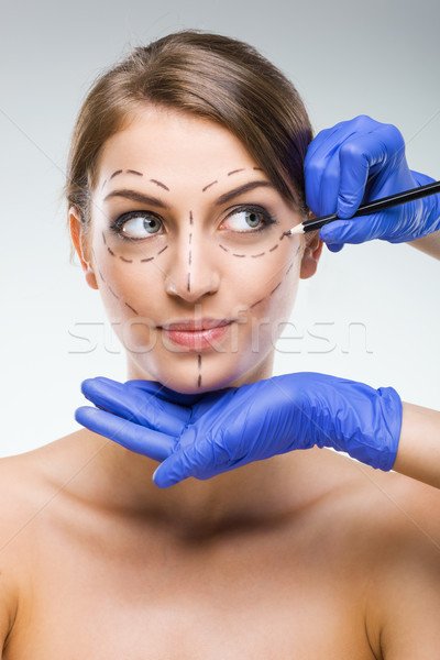 Beautiful woman with plastic surgery, depiction, plastic surgeon hands Stock photo © Geribody