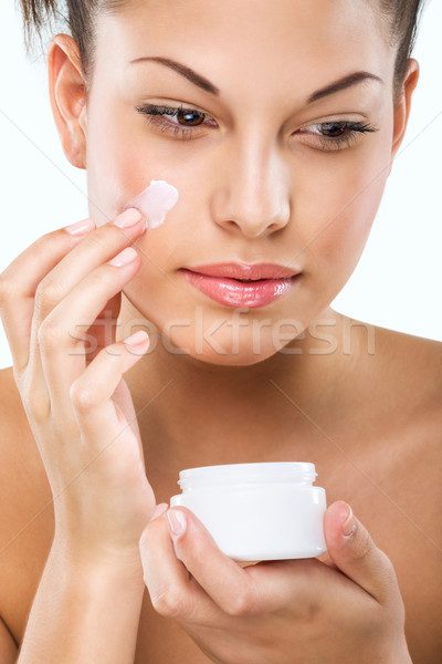 Flawless-skinned woman with moisturizing face cream  Stock photo © Geribody