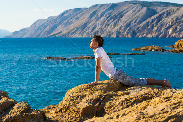 Handsome man in a yoga position on the beach Stock photo © Geribody