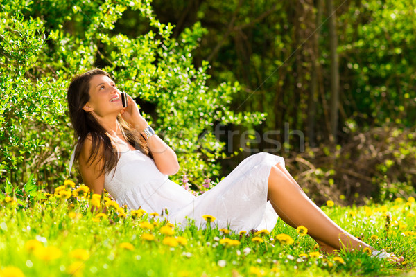 cute young woman speaking on a mobile phone on the grass Stock photo © Geribody