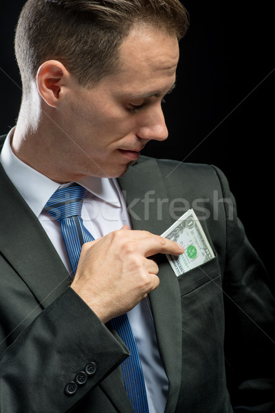 Businessman pulling their money out of pocket Stock photo © Geribody