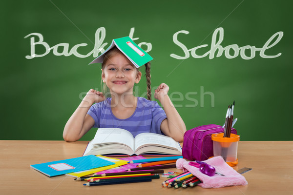 Happy little girl in the school bench, behind Back To School sign on the blackboard  Stock photo © Geribody