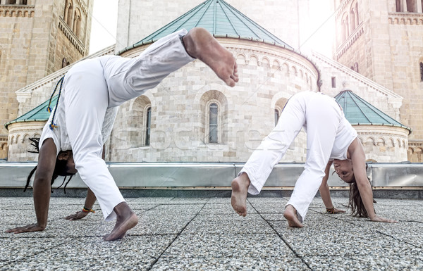 Stock photo: Young pair capoeira partners performing kicks outdoor