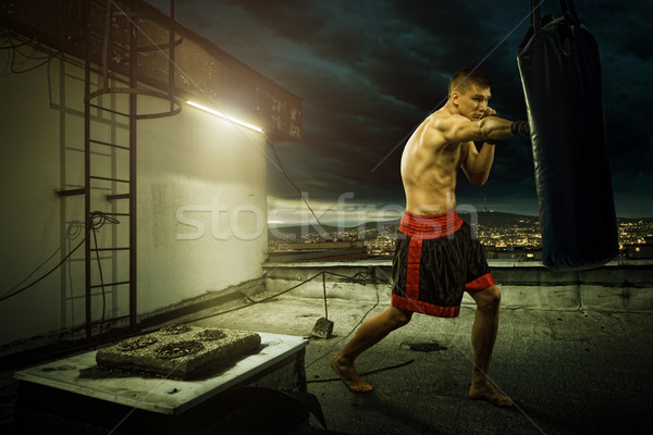 Young man boxing training , on top of the house above the city Stock photo © Geribody