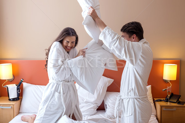 Happy Couple Having Pillow Fight in Hotel Room Stock photo © Geribody