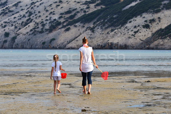 Mother and daughter be fishing nets in the sea  Stock photo © Geribody