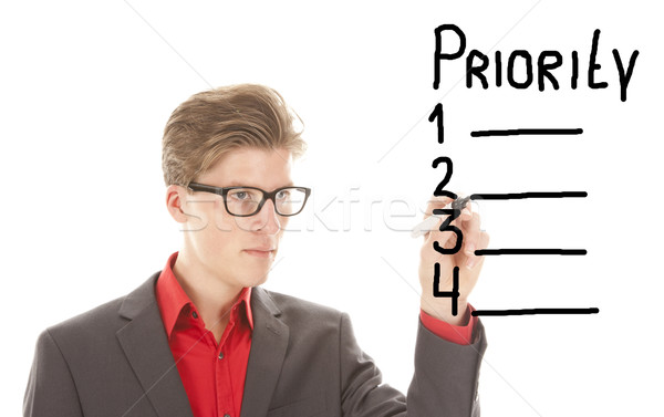 Young man writing priority items isolated on white background Stock photo © gigra