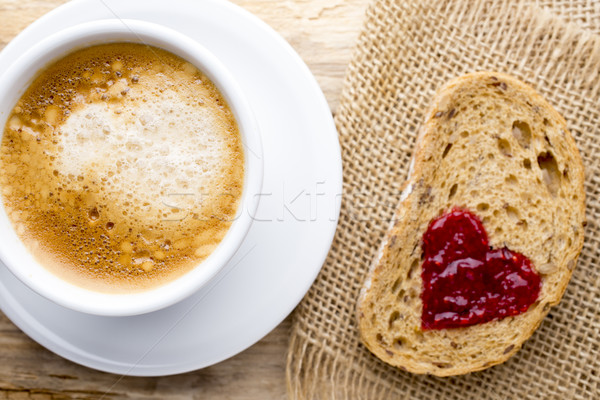 Fresh coffee. Grain slice of bread with jam heart shape. Stock photo © gitusik