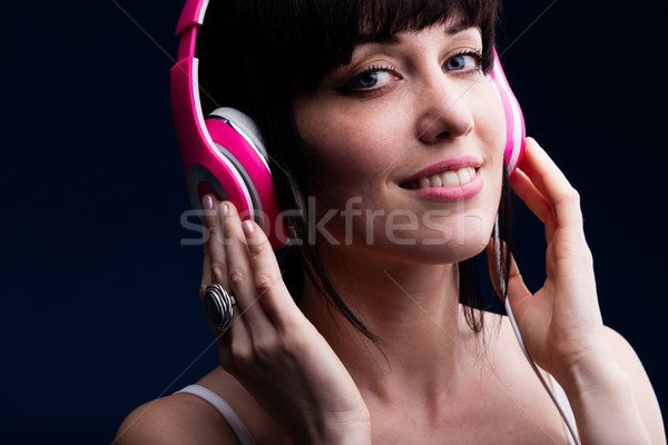 Grinning young adult female using headphones Stock photo © Giulio_Fornasar