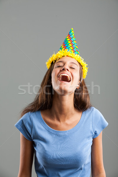 Young woman laughing while wearing a party hat Stock photo © Giulio_Fornasar
