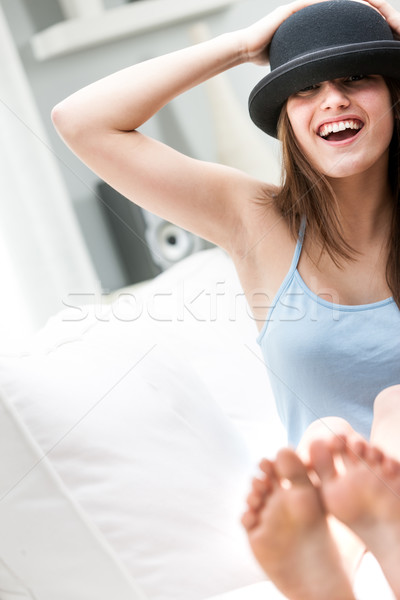 Stock photo: Laughing young barefoot woman in a bowler hat