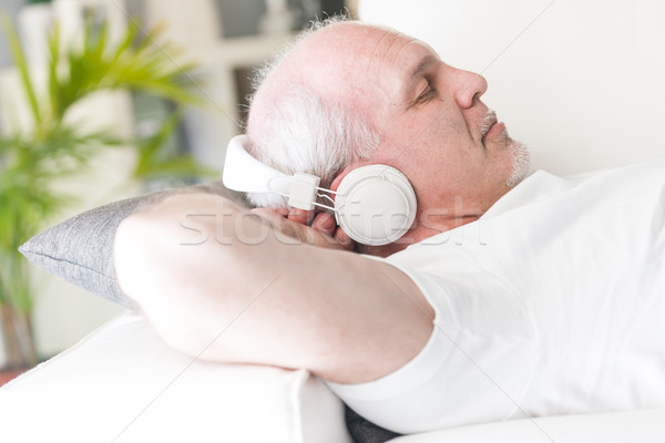 mature man relaxing with music on the sofa Stock photo © Giulio_Fornasar