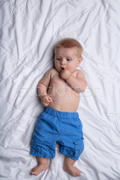 Thoughtful contented little baby lying on his back Stock photo © Giulio_Fornasar