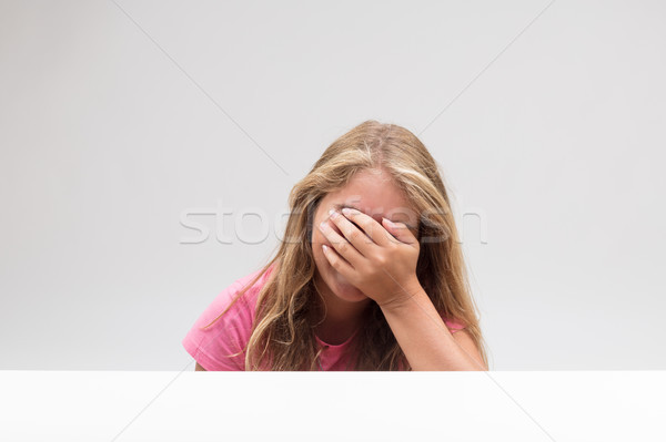 Stock photo: little girl hiding herself behind her hand