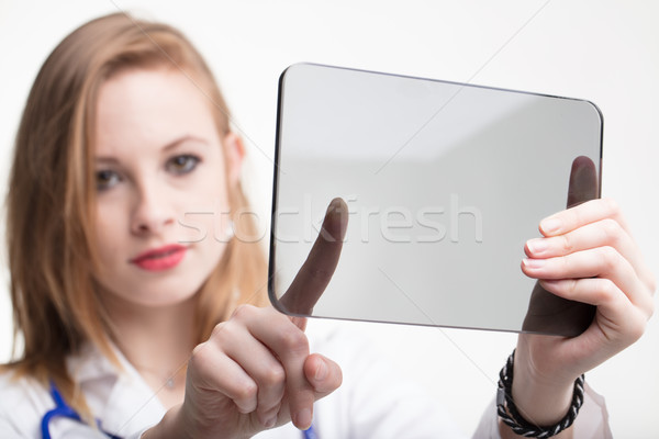 Pretty doctor or nurse using a transparent tablet Stock photo © Giulio_Fornasar