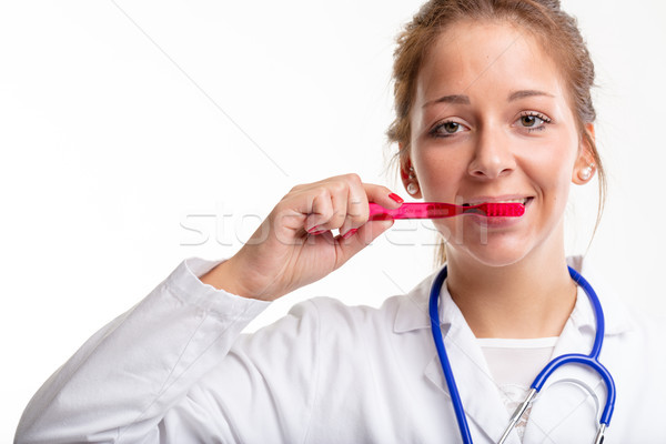 Young dental nurse or doctor brushing her teeth Stock photo © Giulio_Fornasar
